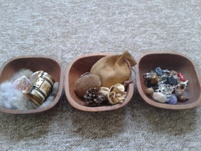 Three wooden bowls containing small items